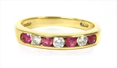 Lot 131 - An 18ct gold diamond and pink sapphire half eternity ring