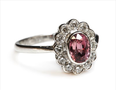Lot 260 - An 18ct white gold sapphire and diamond oval cluster ring