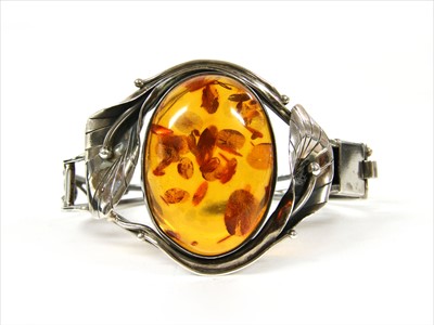 Lot 75 - A sterling silver hinged amber bangle