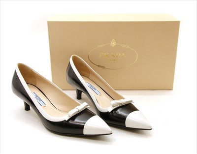 Lot 1051 - A pair of Prada black and white leather court shoes