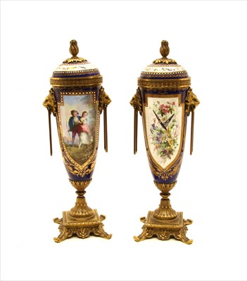 Lot 377 - A pair of Sevres style lidded urns