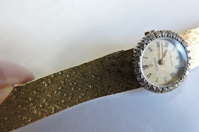 Lot 179 - A ladies' 18ct gold diamond set mechanical bracelet watch