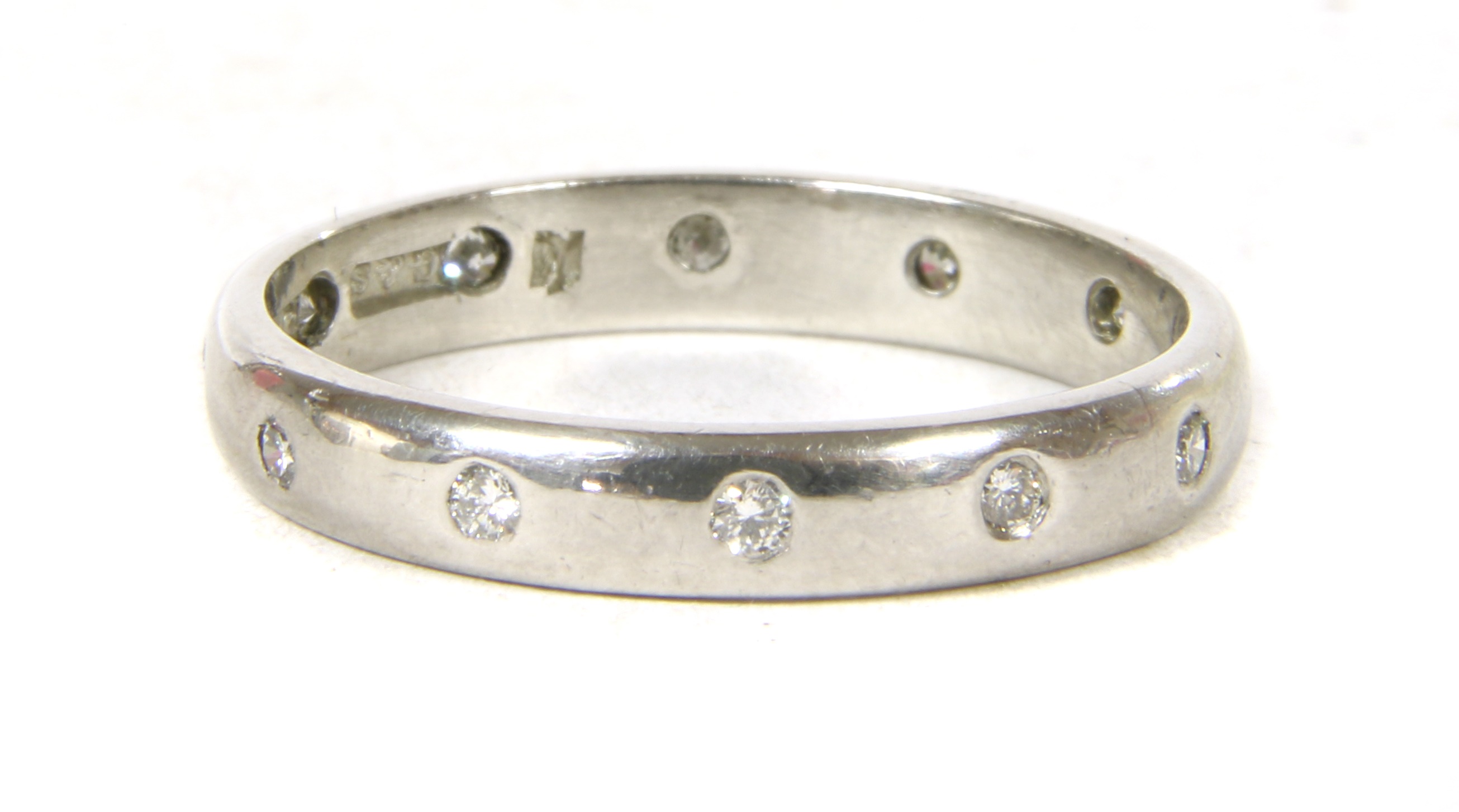 Lot 53 A platinum diamond wedding ring,