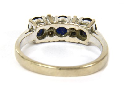Lot 60 - A white gold seven stone sapphire and diamond ring