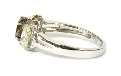 Lot 66 - An 18ct white gold three stone fancy diamond and white diamond regal cluster ring