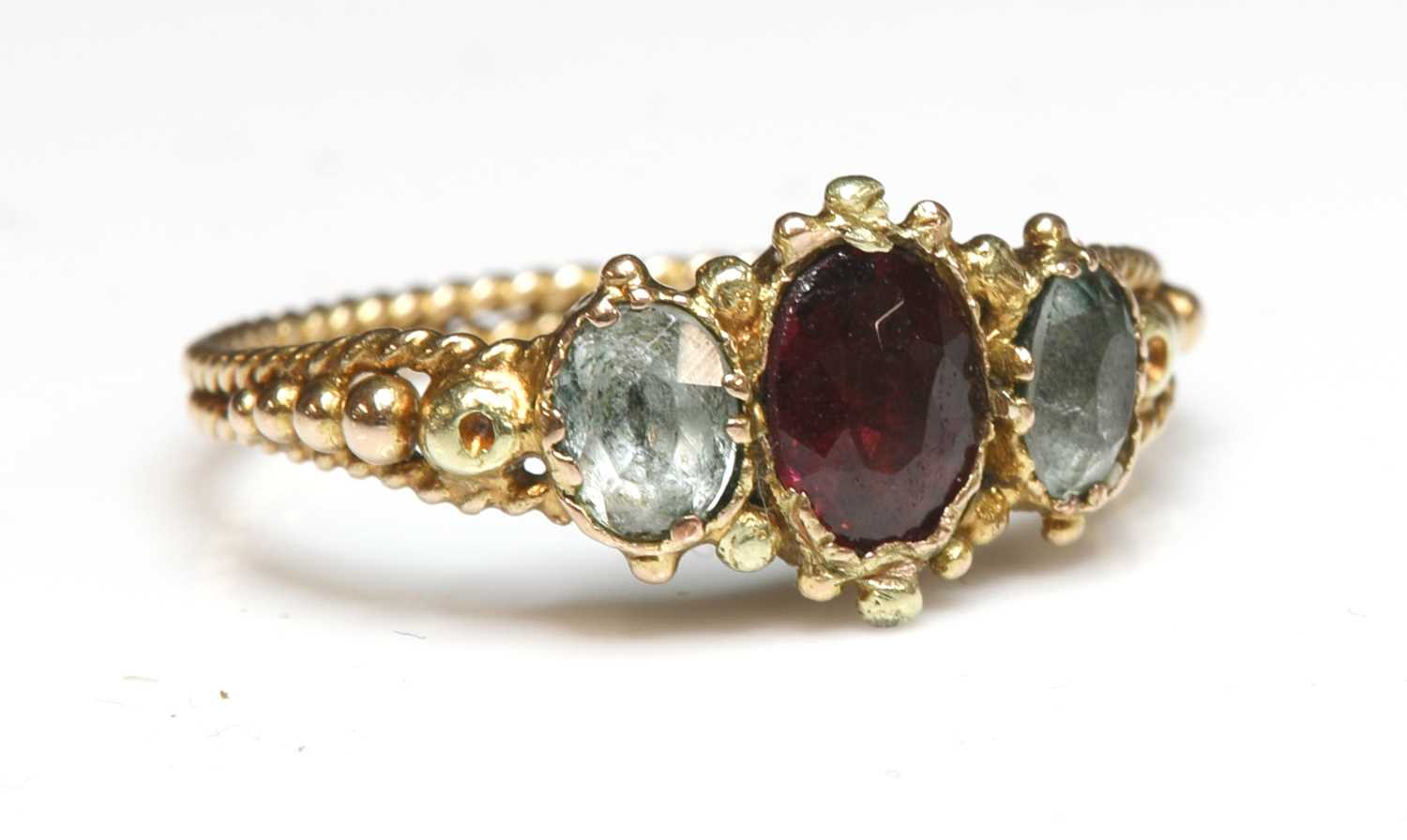Lot 29 - An early Victorian three stone foiled garnet and foiled quartz ring