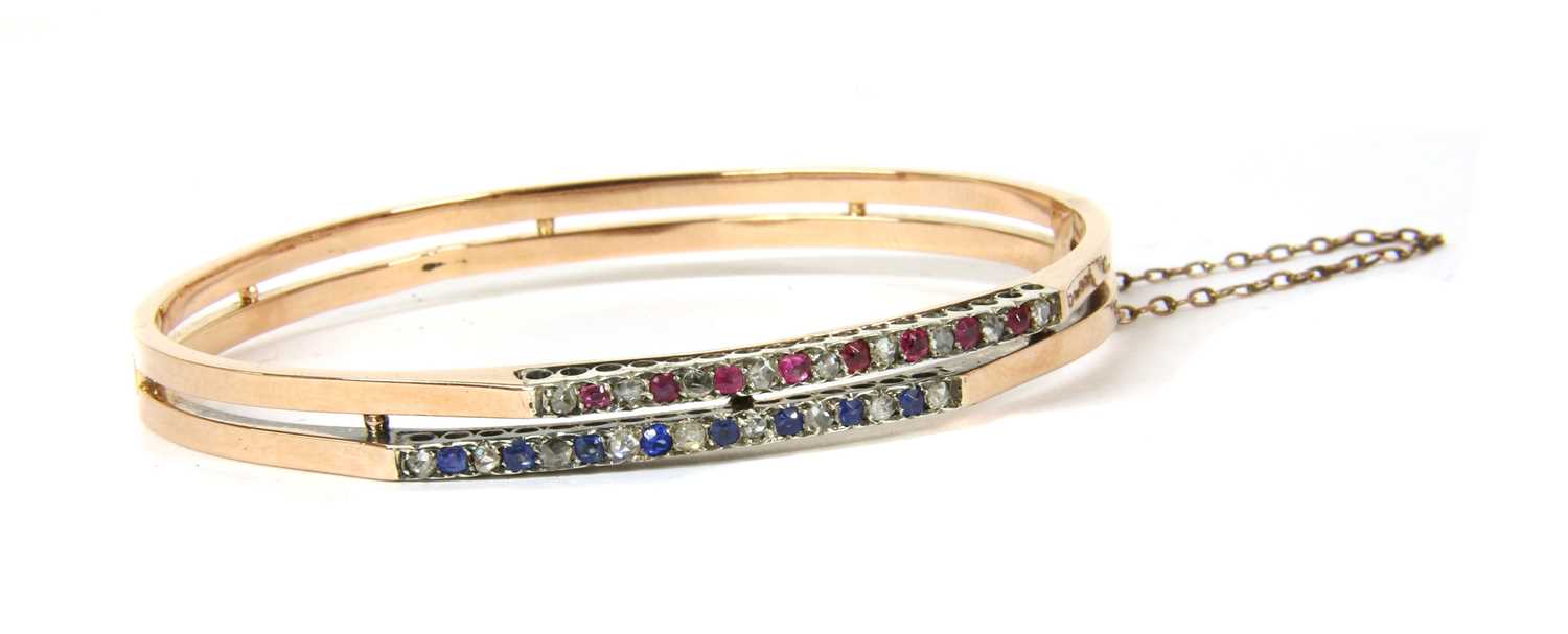 Lot 21 - A French 18ct gold diamond, ruby and sapphire bangle, c.1900