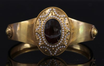 Lot 39 - A Victorian gold garnet and enamel hinged bangle, c.1860
