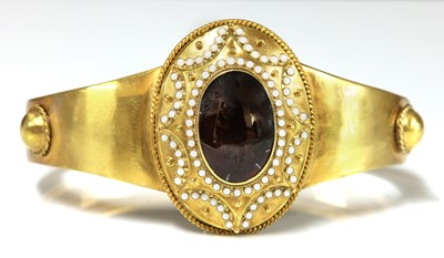 Lot 39 - A Victorian gold garnet and enamel hinged bangle, c.1860