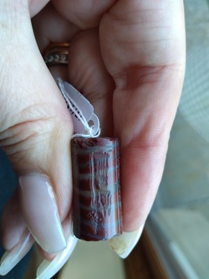 Lot 480 - A Babylonian red banded jasper cylinder seal