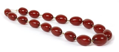 Lot 83 - A single row graduated oval cherry coloured Bakelite bead necklace