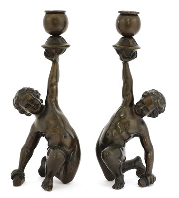 Lot 833 - A pair of bronze figural candlesticks