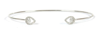 Lot 97 - A white gold diamond torque bangle