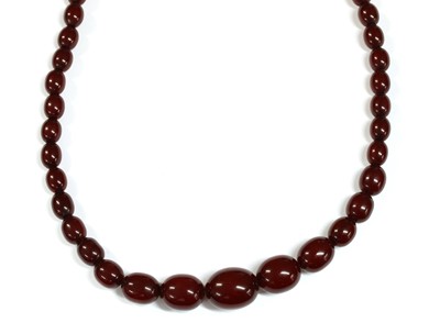 Lot 84 - A single row graduated oval cherry coloured Bakelite bead necklace