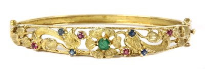 Lot 190 - A 9ct gold emerald, ruby and sapphire set hinged bangle, c.1970