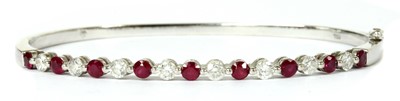 Lot 49 - A white gold ruby and diamond hinged bangle