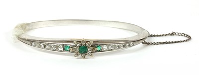 Lot 49 - A Continental emerald and diamond set hinged bangle
