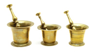 Lot 257 - Three antique brass chemist's pestles and mortars