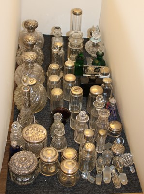 Lot 247 - A large collection of silver topped cut glass perfumes and jars
