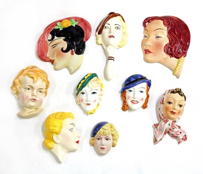 Lot 130 - A collection of nine pottery wall masks
