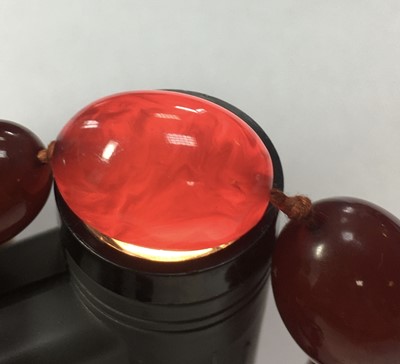 Lot 83 - A single row graduated oval cherry coloured Bakelite bead necklace