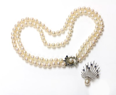 Lot 212 - A two row uniform cultured pearl necklace with a sapphire and diamond clasp
