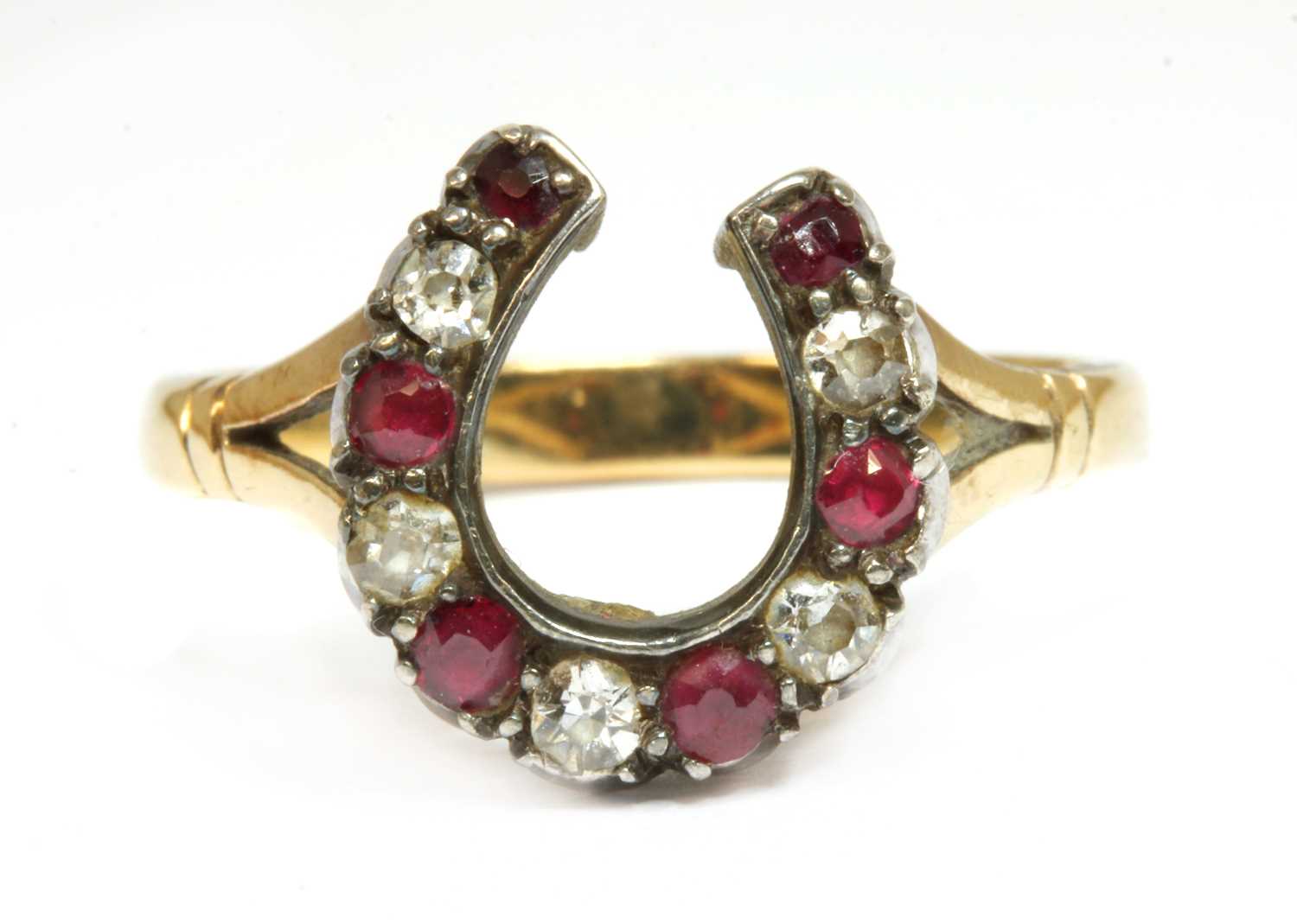 Lot 33 - A gold and silver, diamond and ruby, horseshoe ring