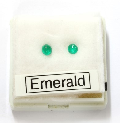Lot 264 - A pair of unmounted oval cabochon emeralds