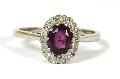 Lot 149 - An 18ct white gold purple sapphire and diamond cluster ring