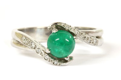 Lot 197 - An 18ct white gold emerald and diamond crossover ring