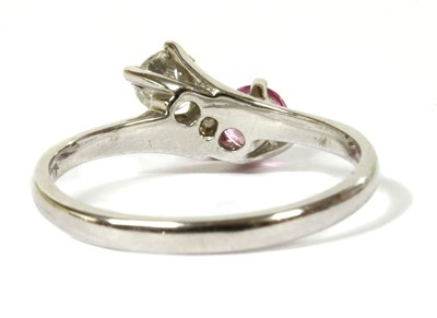 Lot 148 - An 18ct white gold diamond and pink sapphire crossover ring