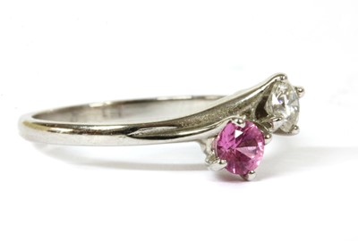 Lot 148 - An 18ct white gold diamond and pink sapphire crossover ring