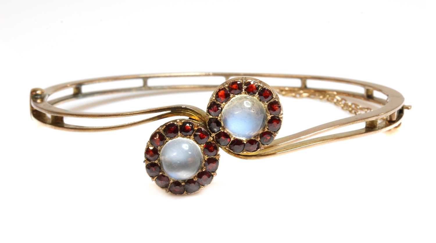 Lot 84 - A gold moonstone and garnet cluster crossover bangle