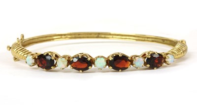 Lot 262 - A 9ct gold opal and garnet hinged bangle, c.1980