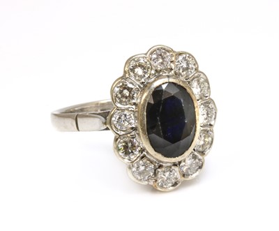 Lot 282 - A white gold sapphire and diamond oval cluster ring