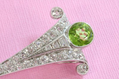 Lot 139 - An Art Deco peridot and diamond clip brooch
