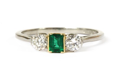 Lot 217 - A platinum and gold, emerald and diamond three stone ring