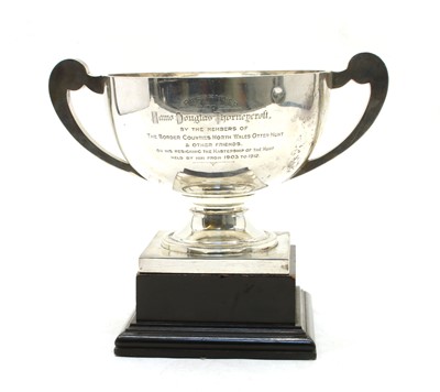 Lot 17 - A George V silver twin handled trophy with scroll handles and square plinth base