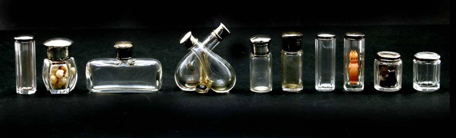Lot 43 - A collection of silver lidded glass scent and drawing table jars