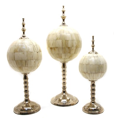 Lot 292 - A set of three modern graduated bone orbs on chromium plated stands and finial mounts