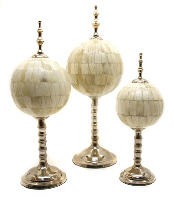 Lot 305 - A set of three modern graduated bone orbs on chromium plated stands and finial mounts