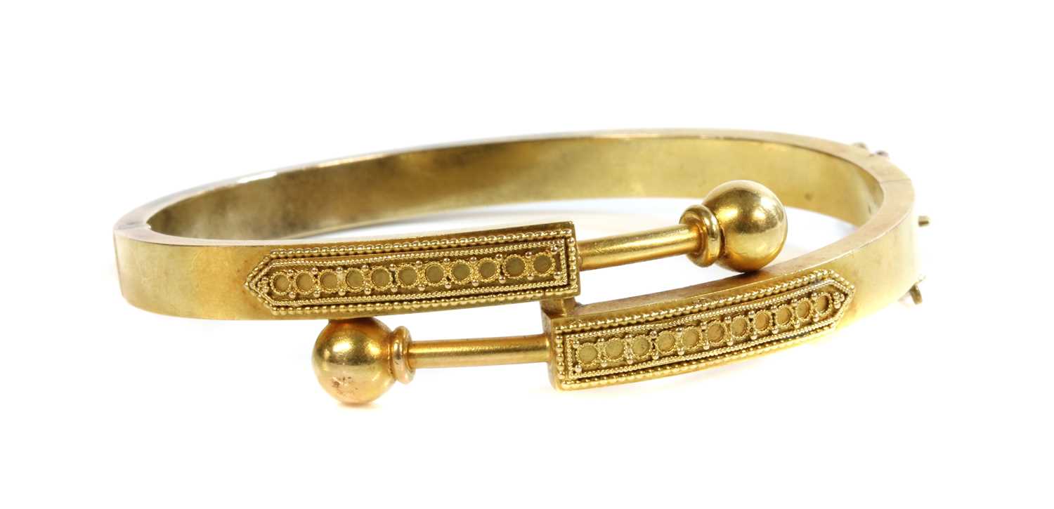 Lot 29 - A Victorian gold, Archaeological Revival, Etruscan-style crossover hinged bangle, c.1870