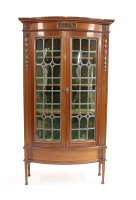Lot 394 - An early 20th century mahogany glazed serpentine fronted display cabinet