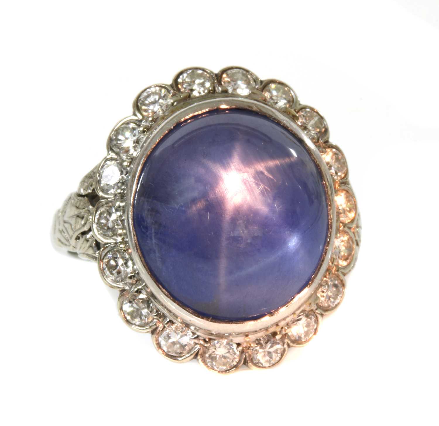 Lot 135 - An American star sapphire and diamond oval cluster ring