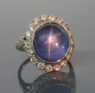 Lot 135 - An American star sapphire and diamond oval cluster ring
