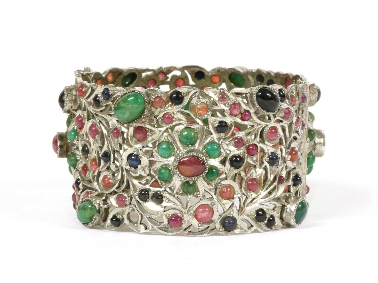 Lot 72 - A silver hinged emerald, ruby and sapphire set bangle