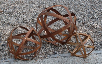 Lot 222 - A graduated set of three contemporary rusted metal strapwork spheres