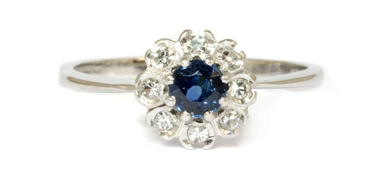 Lot 104 - An 18ct white gold sapphire and diamond cluster ring