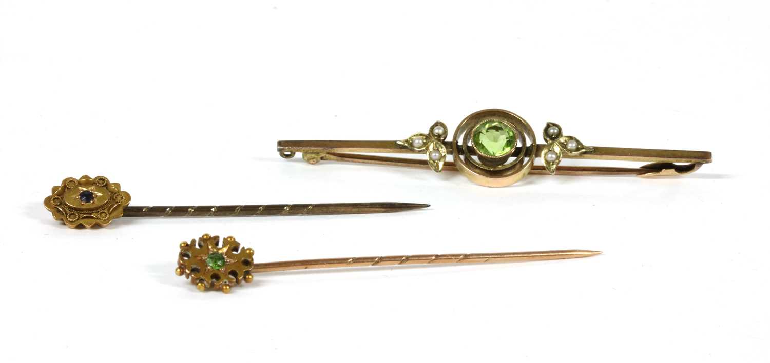 Lot 26 - An Edwardian gold peridot and split pearl bar brooch