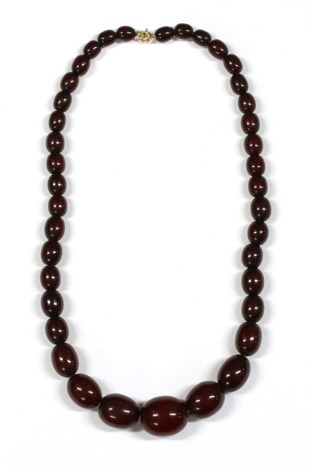 Lot 69 - A single row graduated oval oxblood coloured Bakelite bead necklace
